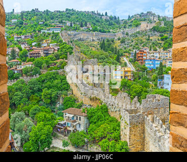 La collina del castello di Alanya con la fortezza di pietra parete è visibile attraverso le merlature della Torre Rossa si trova sulla costa, la Turchia. Foto Stock