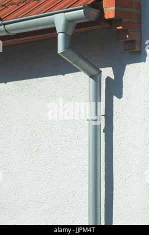 Grigio metallo grondaia sulla casa bianca verticale Foto Stock