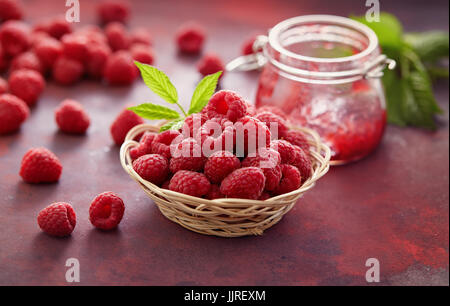 Lamponi freschi e un vasetto di marmellata di lamponi. Foto Stock