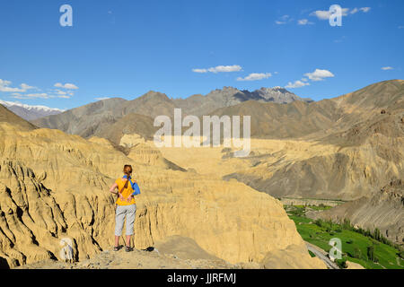 Turistica durante la spedizione nelle montagne del Ladakh è ammirando lo splendido panorama del Karakorum nelle vicinanze della città di Lamayuru. Locali sono naming Foto Stock