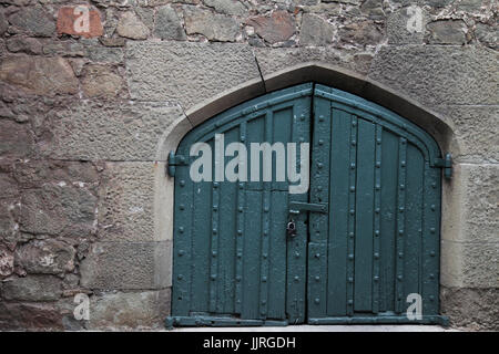 Una grande porta nel vecchio muro di pietra Foto Stock