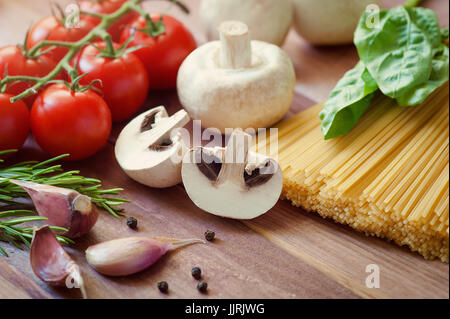 La pasta. Italian Spaghetti con i funghi, il pomodoro ciliegino, parmigiano, basilico e aglio. La cottura della pasta. La cena. Cucina mediterranea Foto Stock