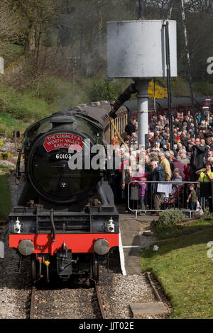 La folla di persone di visualizzare iconico locomotiva a vapore 60103 Flying Scotsman, sbuffando fumo sulle vie - Keighley e Worth Valley Railway Station, Inghilterra, Regno Unito. Foto Stock