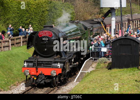 La folla di persone di visualizzare iconico locomotiva a vapore, LNER 60103 Flying Scotsman sbuffando fumo, sulle vie di Keighley e Worth Valley Railway, Inghilterra, Regno Unito. Foto Stock