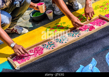 Antigua Guatemala - marzo 26, 2017: locali cucchiaio di segatura di legno tinto attraverso stencil di legno per decorare la quaresima tappeti per processione Foto Stock