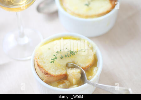 Bianco di piccole ciotole di zuppa di cipolla con formaggio fuso e toast di timo fresco Foto Stock