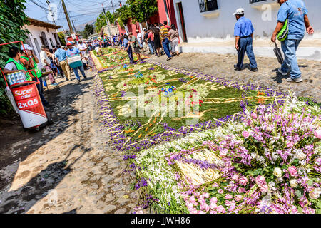 Antigua Guatemala - marzo 26, 2017: la gente fa processione tappeti durante la quaresima contro il fondale di acatenango vulcano in città coloniale Foto Stock