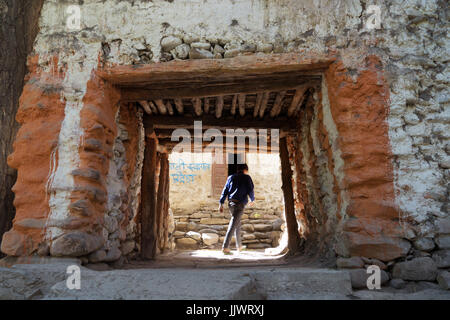 Silhouette di un ragazzo che passa attraverso l'ingresso del villaggio di Chuksang, nel Mustang Superiore regione, Nepal. Foto Stock