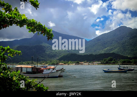 Ilhabela São Paulo, Brasile. Barche in acqua con montagne che incontrano il mare in background. Questa isola è una popolare destinazione turistica. Foto Stock