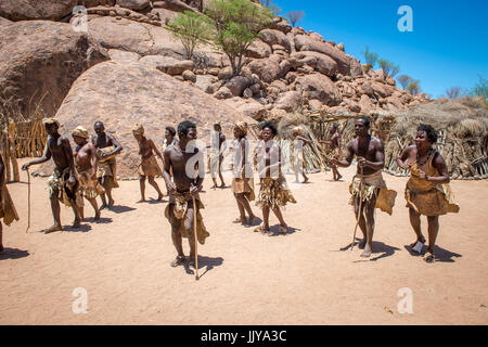 Popoli Damaran alzarsi e cantare in una linea a Damara museo vivente, situato in Twyfelfontein, vicino la Namibia, Africa. Foto Stock