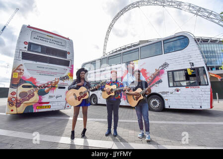 Londra, Regno Unito. Il 21 luglio 2017. Musicisti (L a R) Modupe Obasola, Kal Lavelle e Jay Johnson, che hanno preso parte al sindaco di Londra del musicista di strada annuale competizione, sostare di fronte gli autobus con le loro immagini. Dire Straits frontman Mark Knopfler svela due iconico London bus esterni al Wembley Stadium per festeggiare il lancio di concerti, in associazione con Gibson, alla vigilia del musicista di strada internazionale giorno. Credito: Stephen Chung / Alamy Live News Foto Stock