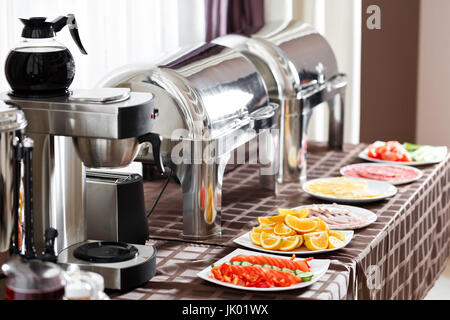 La prima colazione presso l'hotel. Tavolo da Buffet con piatti in attesa per gli ospiti Foto Stock