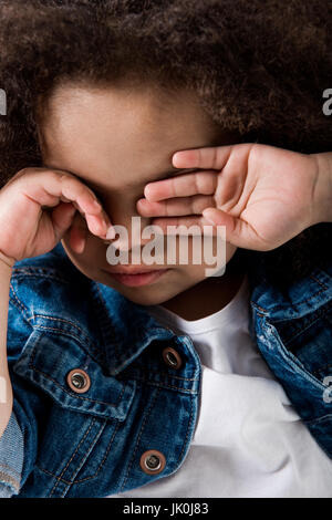 Close-up verticale di sad African American Baby girl asciugare le lacrime Foto Stock