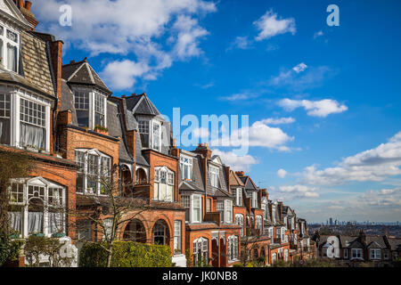 Londra, Inghilterra - mattone tradizionale case e appartamenti in una bella mattina d'estate con cielo blu e nuvole presi da Muswell Hill Foto Stock