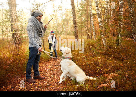 Genitore a giocare con il suo cane e dà un comando Foto Stock