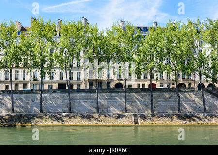 Le rive del fiume Senna con alberi di pioppo e tipici edifici Parigini sull'isola di Saint Louis. Foto Stock