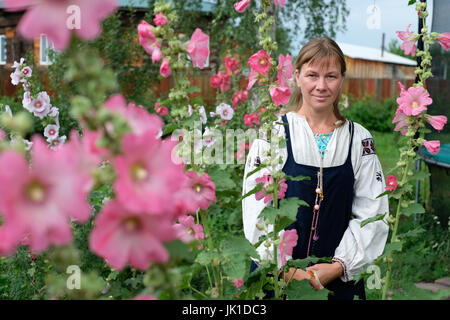 Tatiana Chufeneva discendente della comunità degli antichi credenti che indossa abiti sarafani tradizionali a casa sua nel villaggio di Solonovka nel distretto di Smolensky in Altai Krai, una regione della Siberia occidentale, Russia. Gli antichi credenti o gli antichi rituali sono cristiani ortodossi orientali che mantengono le pratiche liturgiche e rituali della Chiesa russa come erano prima delle riforme del Patriarca Nikon di Mosca tra il 1652 e il 1666. Resistendo all'accoglienza della pietà russa alle forme contemporanee di culto greco-ortodosso, Foto Stock