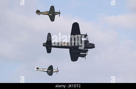 Un bombardiere Lancaster e due Spitfires eseguire una Battaglia di Bretagna memorial volo al lancio del Sunderland Airshow internazionale. Foto Stock