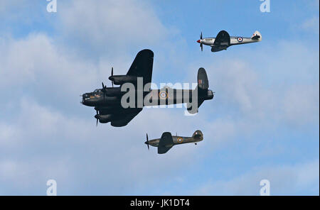 Un bombardiere Lancaster e due Spitfires eseguire una Battaglia di Bretagna memorial volo al lancio del Sunderland Airshow internazionale. Foto Stock