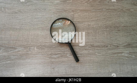 Lente di ingrandimento in laminato grigio Sfondo. Foto Stock