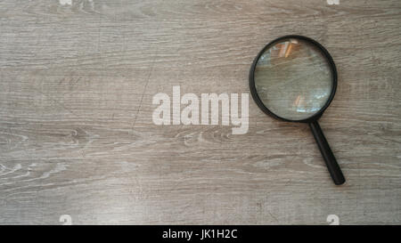 Lente di ingrandimento in laminato grigio Sfondo. Foto Stock