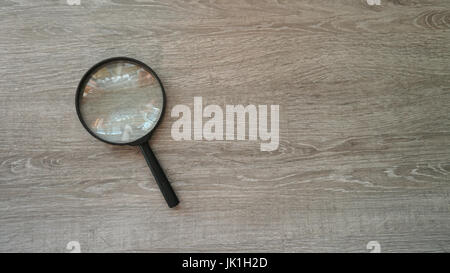 Lente di ingrandimento in laminato grigio Sfondo. Foto Stock
