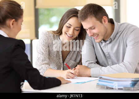 Coppia felice firma un contratto insieme a office Foto Stock