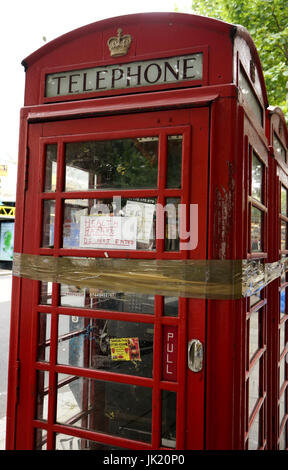 Close up inutilizzato, fissati con nastro, vandalizzato telefono rosso scatola, Londra, Inghilterra Foto Stock