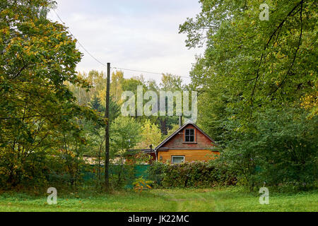 Riga, Lettonia - 12 Ottobre 2012: piccolo marrone casa in legno nella periferia di Riga nella foresta Foto Stock