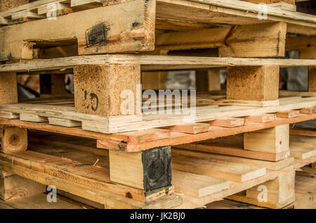 Al di fuori di vecchi fabbricati in legno euro standard pallet stoccati in tralicci. Foto Stock