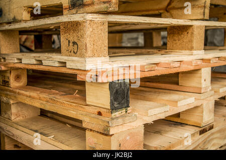 Al di fuori di vecchi fabbricati in legno euro standard pallet stoccati in tralicci. Foto Stock