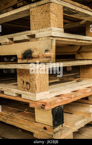 Al di fuori di vecchi fabbricati in legno euro standard pallet stoccati in tralicci. Foto Stock