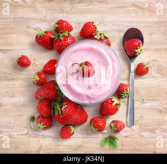 Yogurt con fragole fresche su sfondo di legno. Dieta frutta concetto. Vista dall'alto, alta risoluzione prodotto. Foto Stock