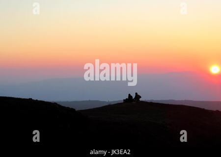 Un paio di sedersi su una collina stagliano dal sole al tramonto vicino al Monte Bental in Israele il Golan. Foto Stock