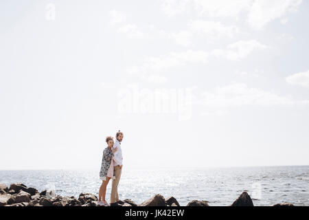 Medio Oriente matura in piedi su rocce vicino oceano Foto Stock