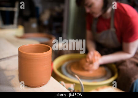 Tazza vicino donna caucasica sagomatura di argilla in ceramica su ruota Foto Stock