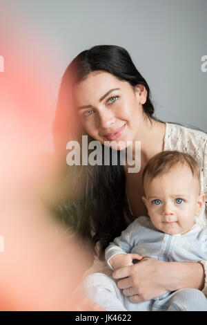 Ritratto di Madre caucasica tenendo il figlio in giro Foto Stock