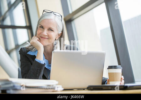 Ritratto di sorridere Caucasian imprenditrice utilizzando laptop Foto Stock
