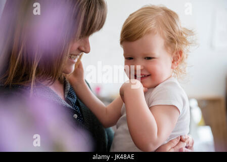 Madre caucasica holding ridere figlia Foto Stock