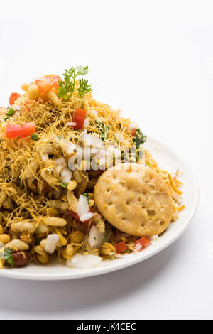 Europea Bhel Puri - popolare strada di Mumbai cibo servito con il coriandolo e chutney di tamarindo su sfondo bianco, il fuoco selettivo Foto Stock