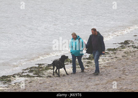 Sandylands Promenade Morecambe Lancashire, Regno Unito. 22 Luglio, 2017. Giovane a piedi il loro cane lungo il bordo delle acque sulla spiaggia Sandylands in Morecambe Credito: David Billinge/Alamy Live News Foto Stock