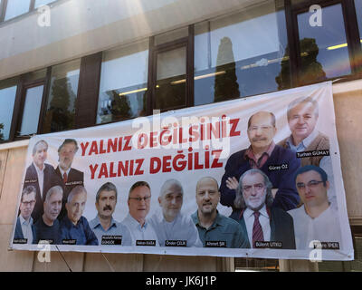 Istanbul, Turchia. 12 Luglio, 2017. Un poster con i volti degli arrestati Cumhuriyet-dipendenti appeso di fronte al palazzo del governo critico quotidiano 'Cumhuriyet' ad Istanbul in Turchia, 12 luglio 2017. Si dice, "non siete soli. Non siamo soli". Foto: Mirjam Schmitt/dpa/Alamy Live News Foto Stock