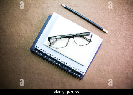 Gli accessori business sul desktop: notebook,matita, bicchieri. Con vignette Foto Stock