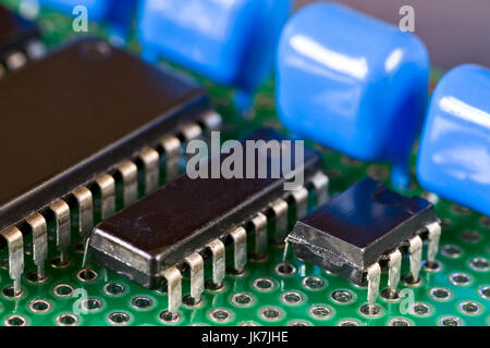 Circuiti integrali e condensatori sulla scheda a circuito stampato Foto Stock