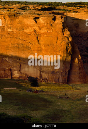 Canyon De Chelly, Arizona: visualizza N dal nodo si affacciano ad un Navajo hogan (multi-sided log house) e fattoria in pietra arenaria canyon fondo. Foto Stock