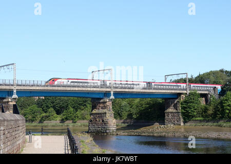 Il Pendolino elettrico unità multiple in treno in Vergine Costa Ovest livrea sulla linea principale della costa occidentale attraversando Carlisle ponte sopra il fiume Lune in Lancaster. Foto Stock