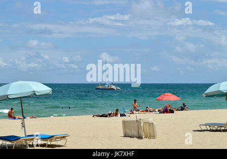 I turisti sulla spiaggia godendosi il sole Foto Stock