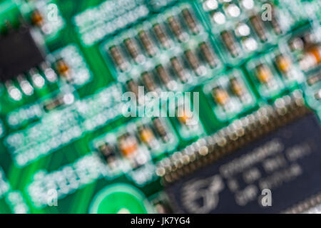 Al di fuori della messa a fuoco immagine di componenti su un verde scheda a circuito stampato (pcb). Foto Stock