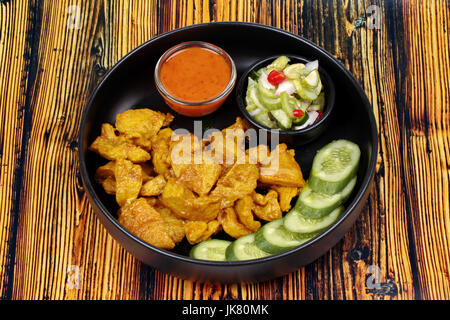 Carbone di legna bollito di maiale satay, fatti in casa, servita con il cetriolo salsa chili come Ar Jad in Thai e salsa di dado sono popolari cucina asiatica. Foto Stock