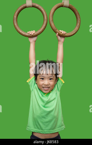 Cinese asiatici bambina appeso sul ring negli isolati di sfondo verde Foto Stock